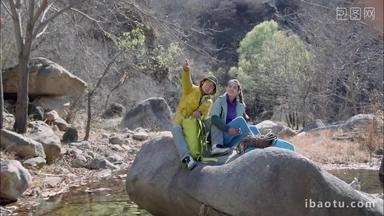 青年登山者伴侣坐在石头上休息